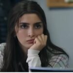 Kadr ukazuje Duygu, która opiera brodę na dłoni i smutno spogląda w stronę biurka Aliego.