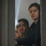 Canan, Zuhal i Cicek wyglądają przez okno.