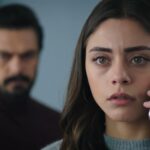 Seher rozmawia przez telefon. Yaman stoi tuż za nią.