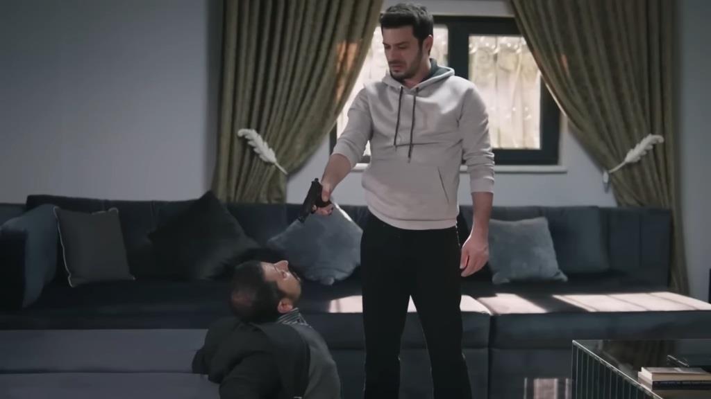 Aziz stoi nad bratem i celuje w niego.