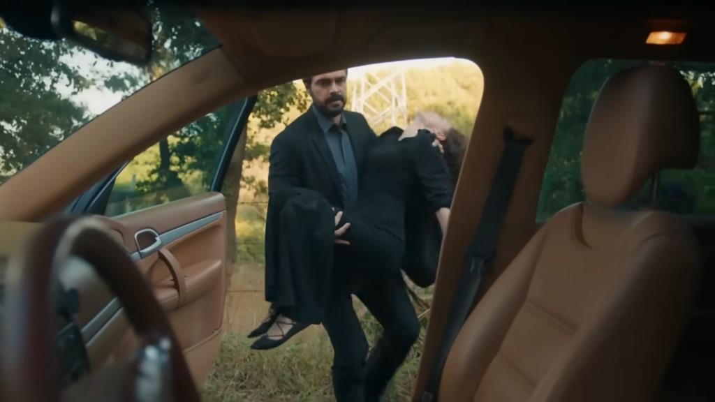 Yaman wnosi nieprzytomną Nanę do samochodu.