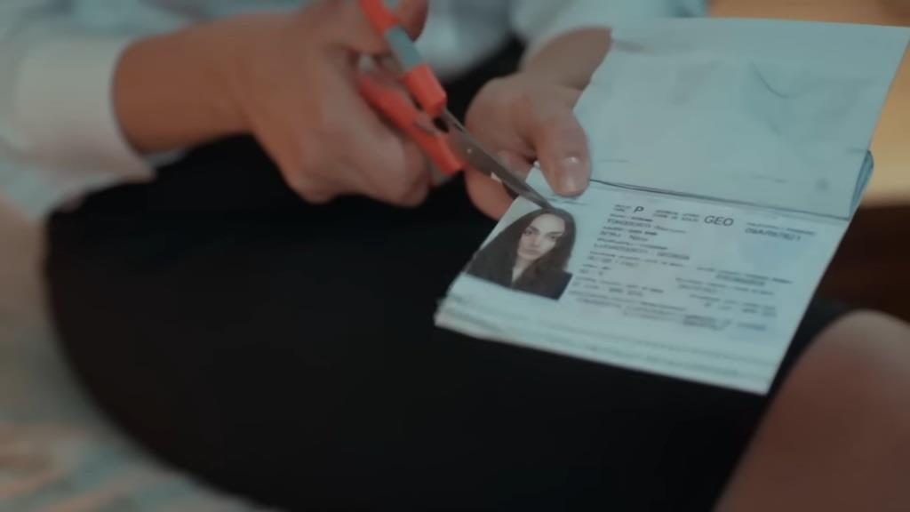 Aynur rozcina nożyczkami paszport Nany.
