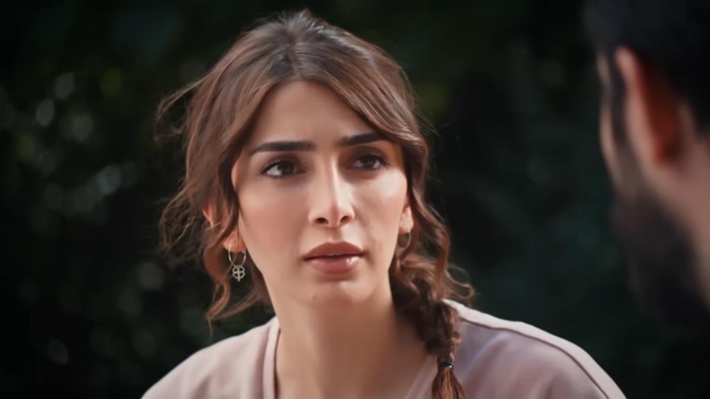 Duygu spogląda z malującym się na twarzy zaskoczeniem.