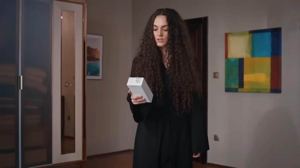 Nana trzyma w ręku pudełko z telefonem.
