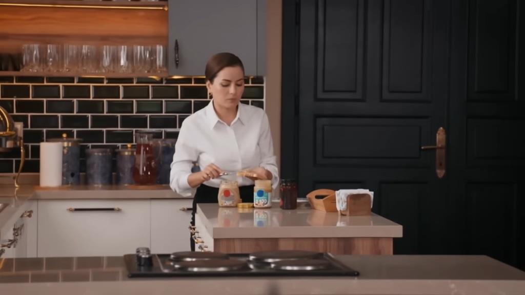 Aynur smaruje chleb masłem orzechowym.