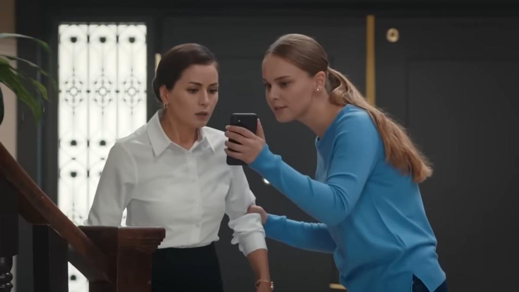 Neslihan pokazuje Aynur coś na telefonie.