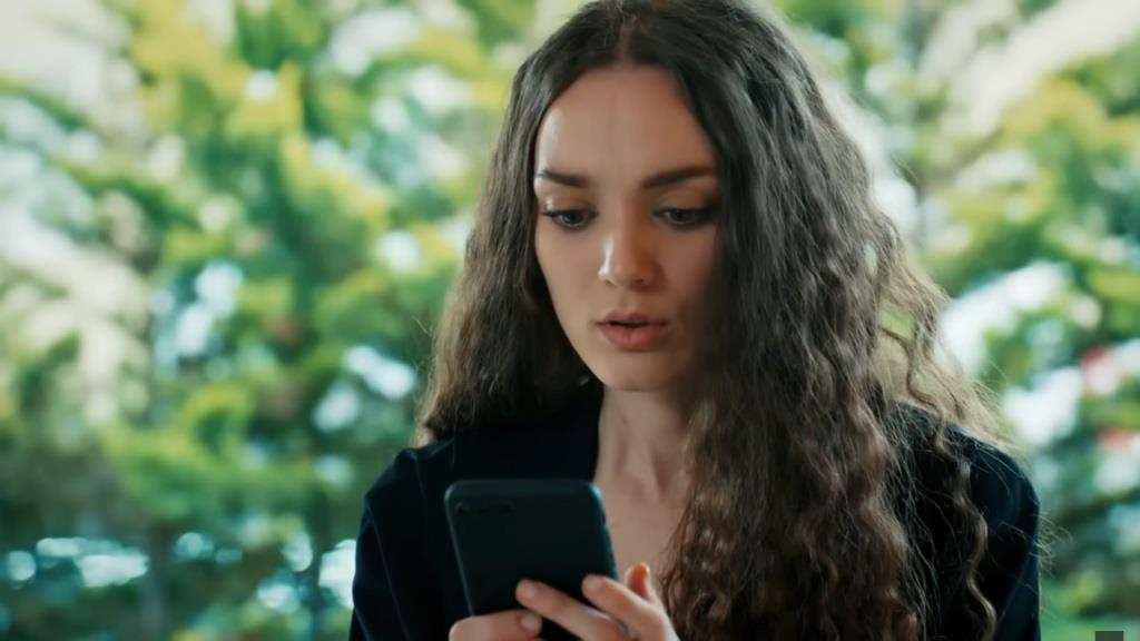 Nana patrzy z niepokojem na swój telefon.