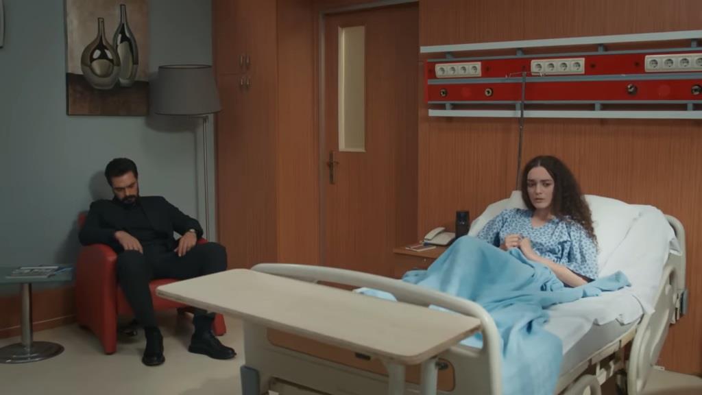 Yaman zasnął na fotelu w sali Nany. Leżąca na łóżku dziewczyna wydaje się zniecierpliwiona.