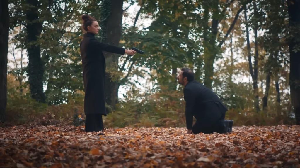 Nana celuje do klęczącego przed nią Idrisa.