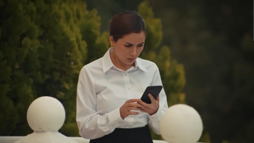 Aynur z telefonem Nany w rękach.