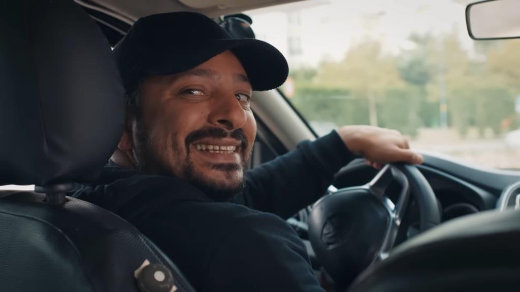 Kierowca taksówki odwraca się z uśmiechem, ujawniając swoją prawdziwą tożsamość - to Idris.