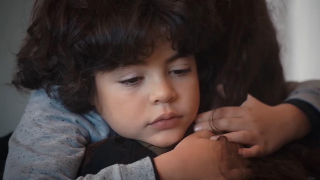 Yusuf przytula się do Nany. Jego twarz wyraża smutek.