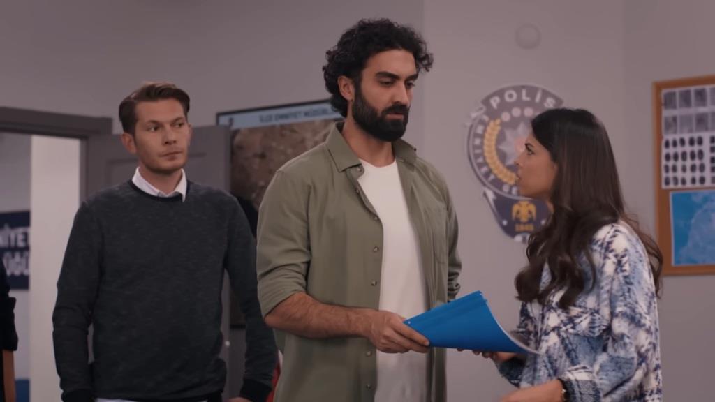 Ferit podaje Ayse teczkę z dokumentami. Za jego plecami stoi Ertan.