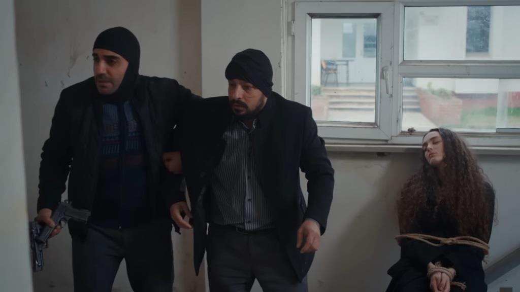 Nana jest nieprzytomna i przywiązana do krzesła. Kazim i Idris znajdują się w tym samym pomieszczeniu, odwróceni do niej plecami, z odsłoniętymi kominiarkami.