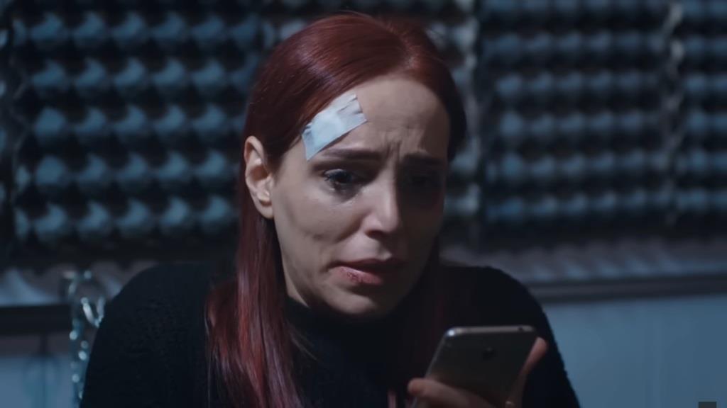 Nilgun, zamknięta w sekretnym pokoju, rozmawia przez telefon.,