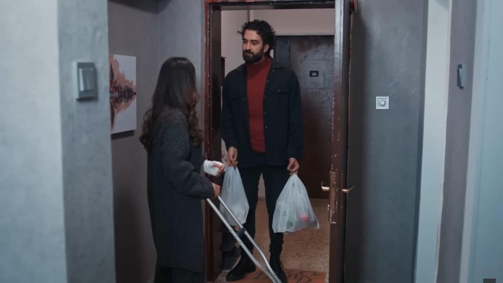 Ferit zjawia się w mieszkaniu Ayse. W rękach trzyma reklamówki z zakupami spożywczymi.