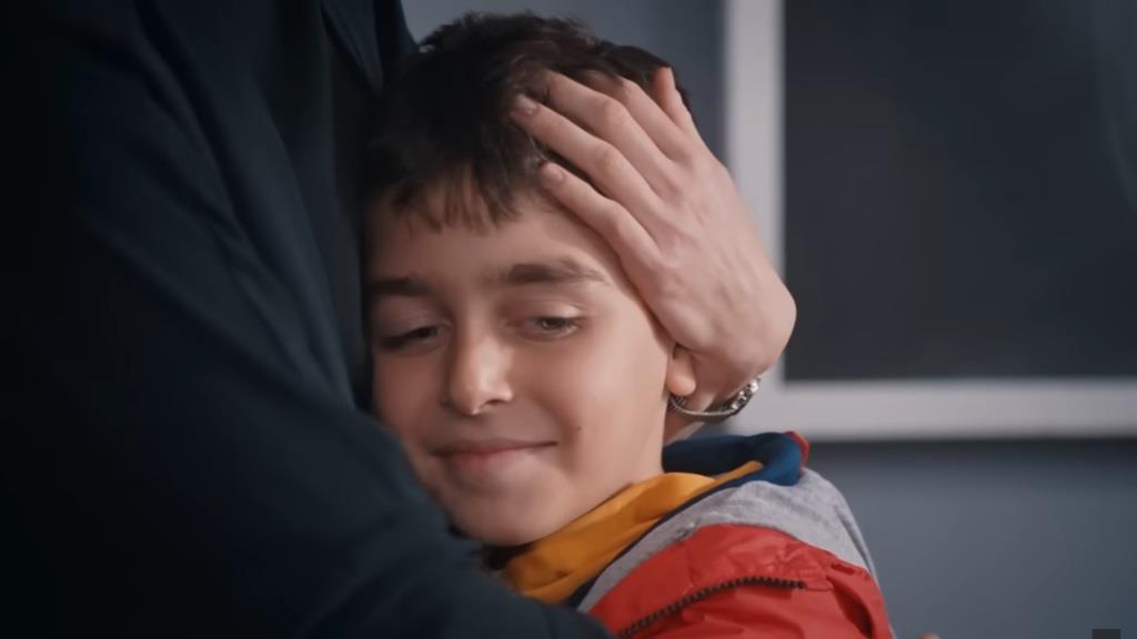 Zbliżenie na twarz Hakana, tulącego się do Nany.