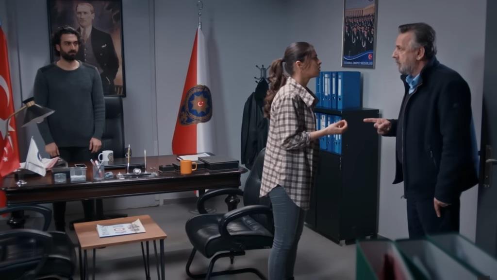Ayse rozmawia ze swoim ojcem w gabinecie Ferita, który stoi za swoim biurkiem.