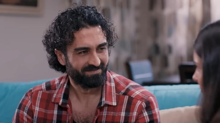 Ferit uśmiecha się, patrząc na Ayse.