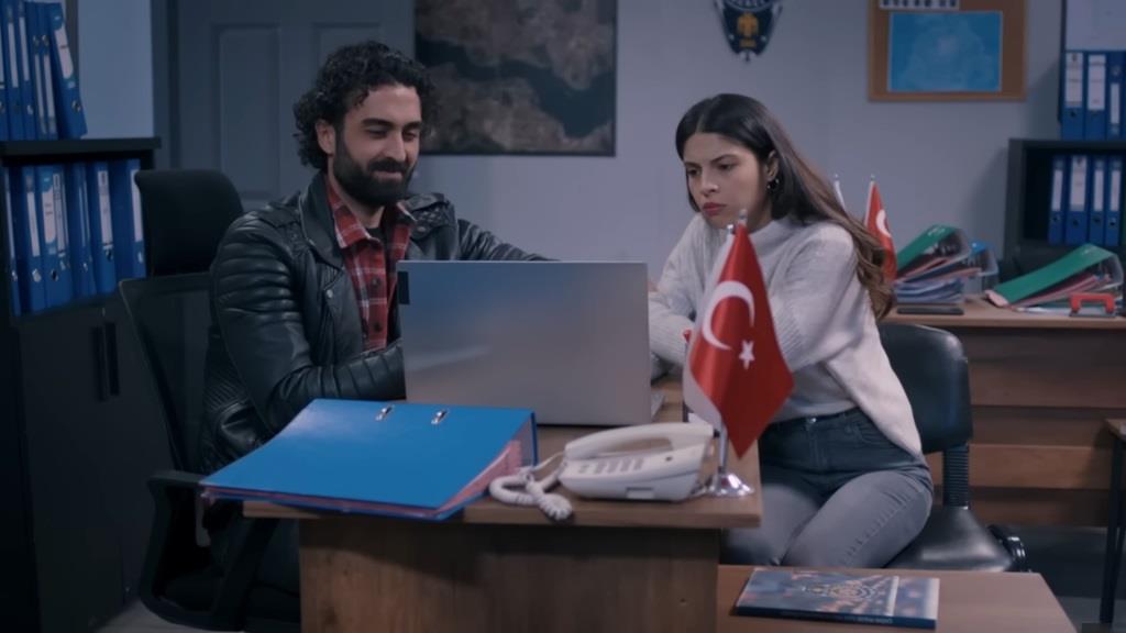 Ferit i Ayse patrzą w ekran laptopa.