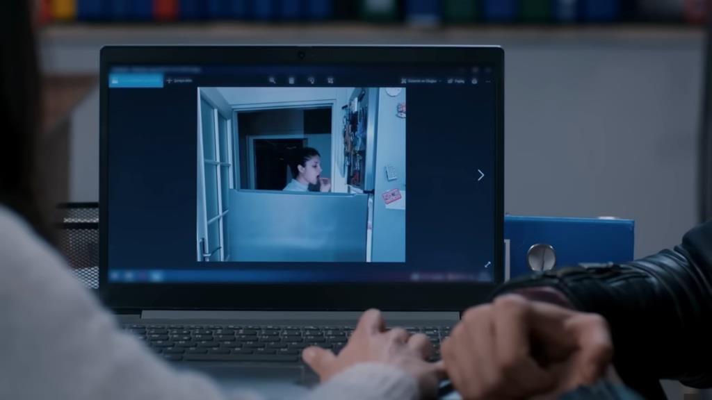 Na ekranie laptopa widnieje zdjęcie Ayse, która nocą wyjada jedzenie z lodówki.