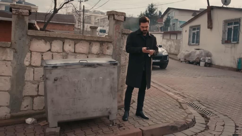 Yaman stoi obok kontenera.