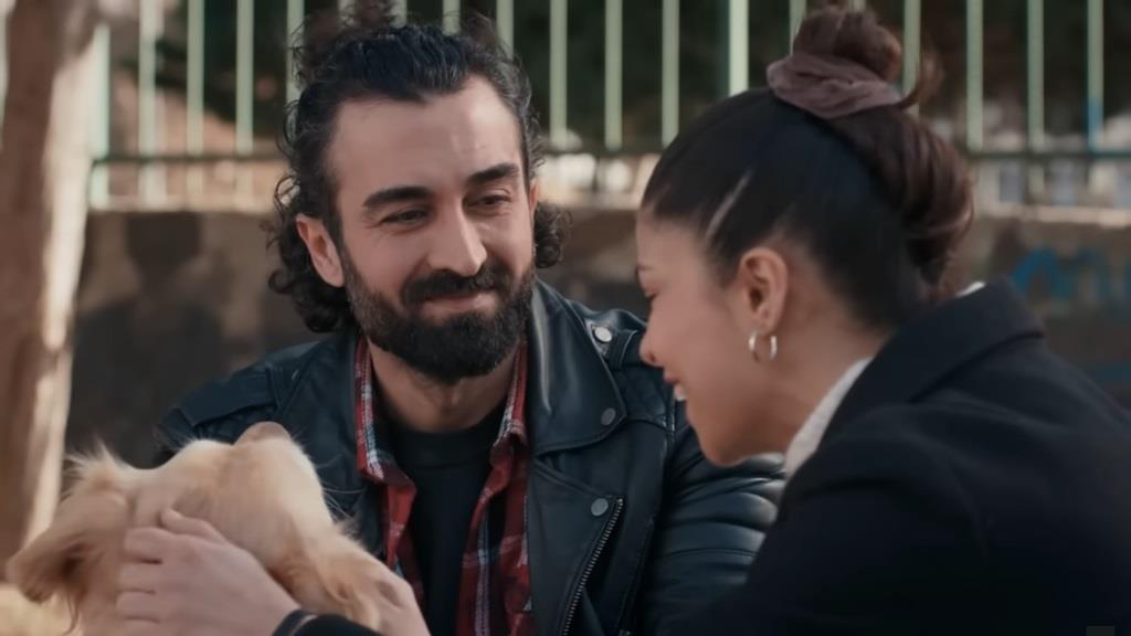 Ferit i Ayse bawią się z psem. Mężczyzna jest wpatrzony w Ayse.