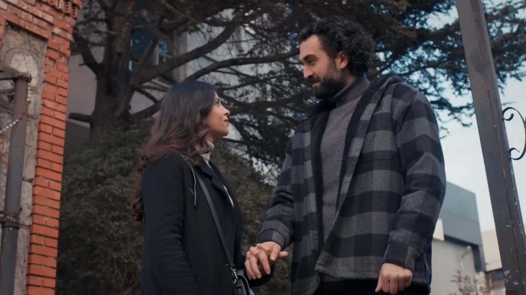 Ayse i Ferit patrzą sobie w oczy, trzymając się za ręce.