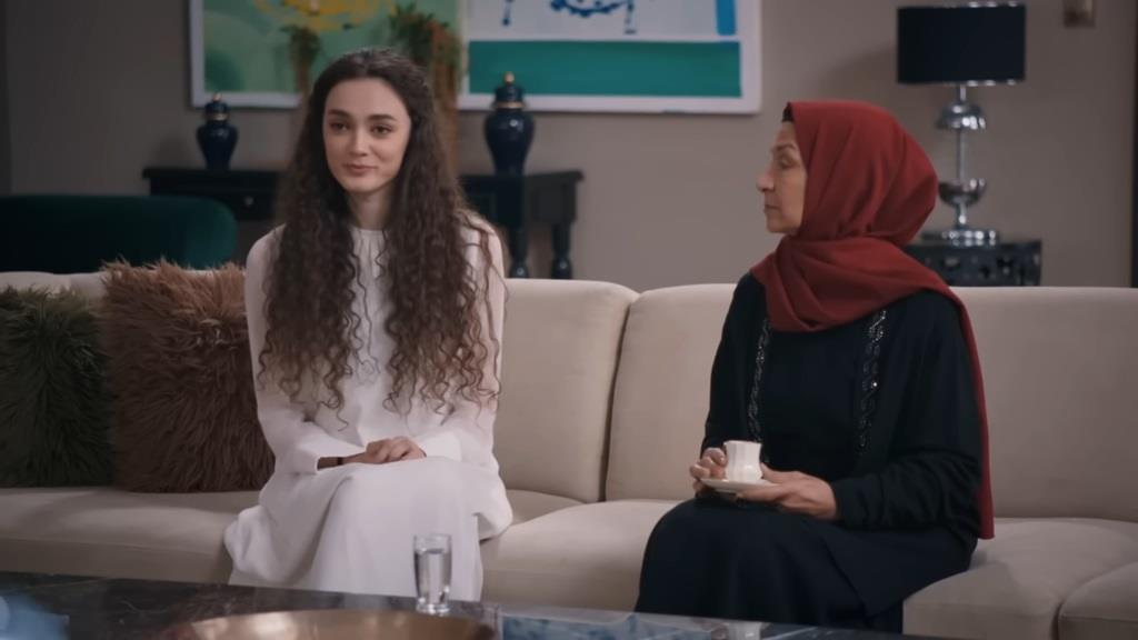 Akca trzyma w rękach filiżankę i patrzy na siedzącą obok niej Nanę.