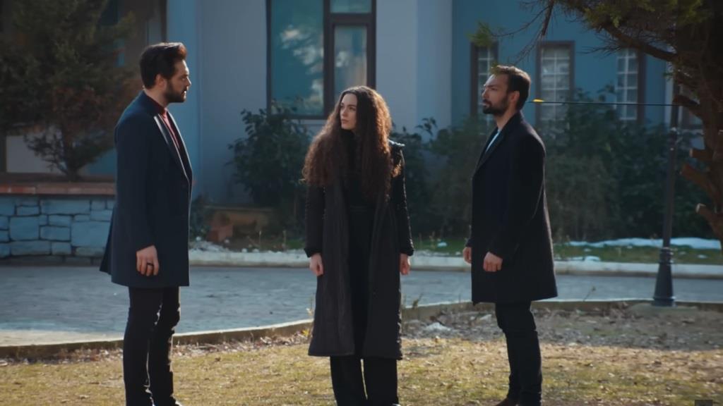 Yaman, Nana i Kubilay stoją obok siebie w ogrodzie.