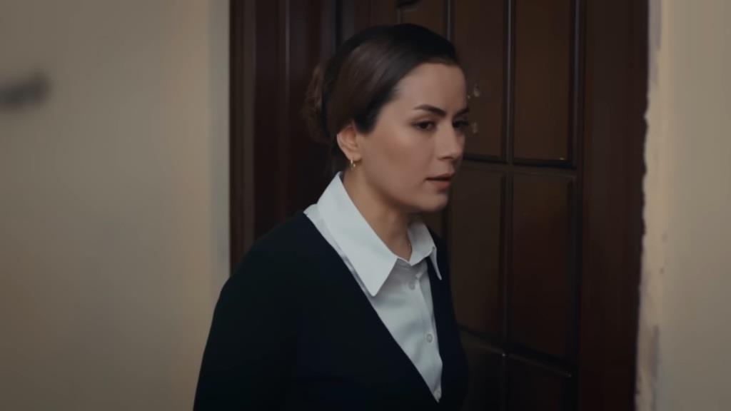 Aynur stoi pod drzwiami spiżarni.