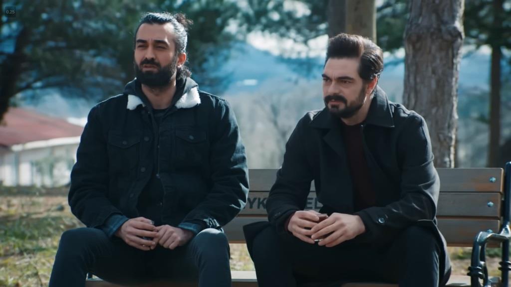 Ferit i Yaman siedzą na ławce w parku.