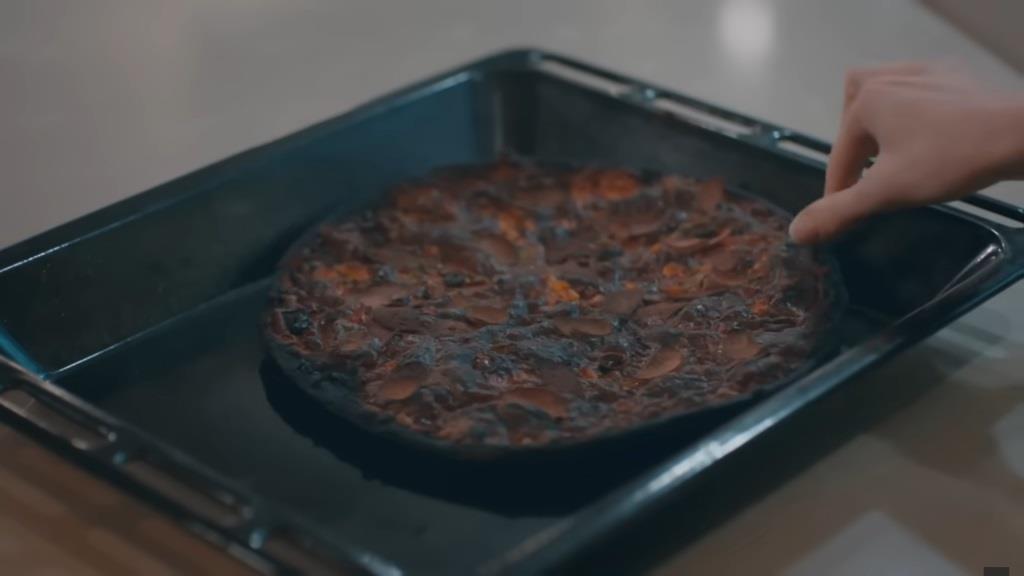 Zbliżenie na spaloną pizzę.