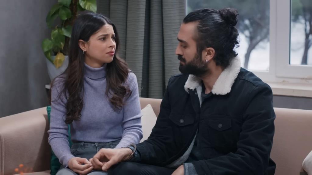 Ayse i Ferit siedzą na sofie, wpatrzeni w siebie.