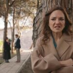 Songul opiera się plecami o pień drzewa. W tle widać stojących w alejce parku Zeynep i Bulenta.