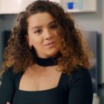 Melis uśmiecha się triumfalnie.