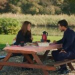Kuzey i Elif rozmawiają przy stole w ogrodzie jego domu.