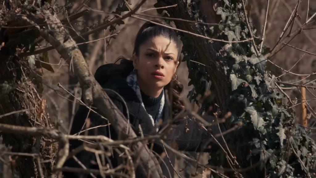 Ayse wygląda zza krzaków.