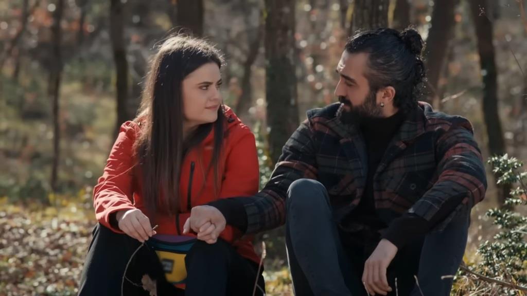 Didem i Ferit rozmawiają, siedząc w lesie.