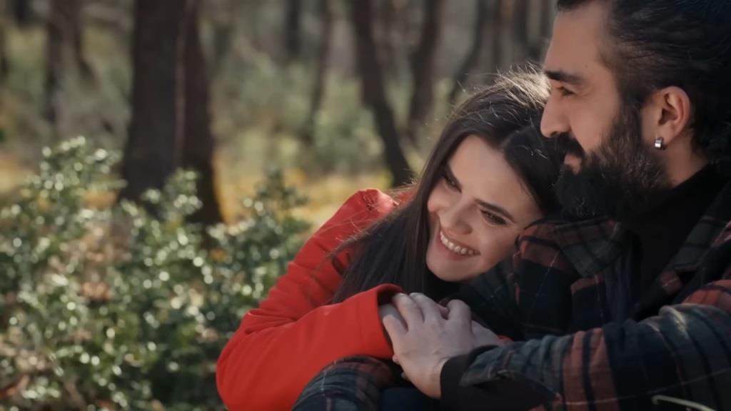 Didem przytula głowę do ramienia Ferita i uśmiecha się.