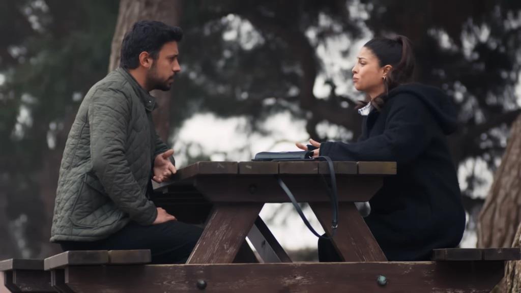 Ayse i Koray siedzą przy stole w parku.