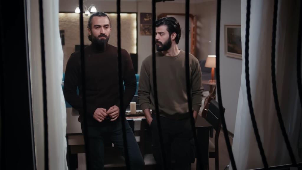 Ferit i Volkan stoją za oknem.