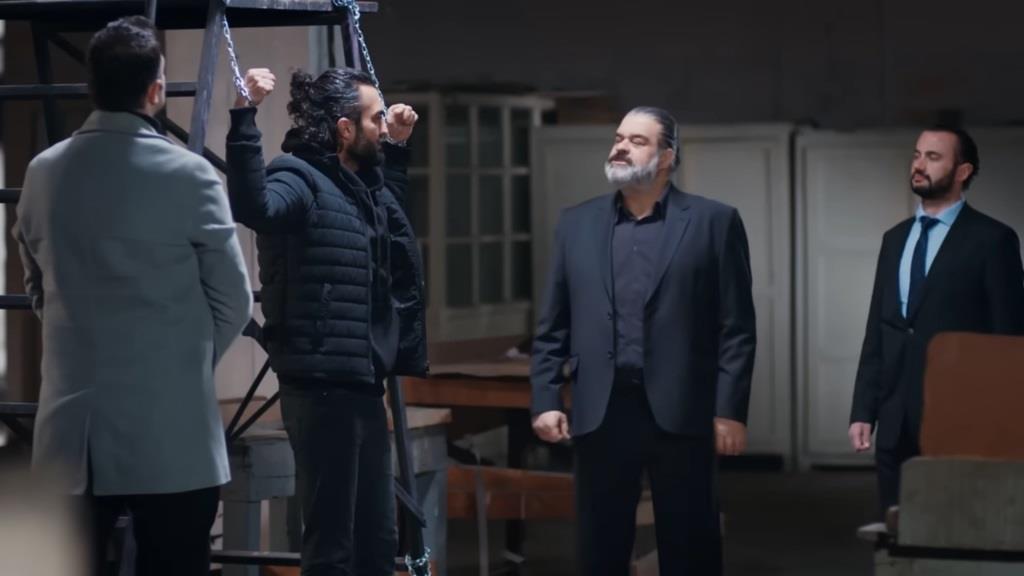 Scena w magazynie, do którego trafił uprowadzony Ferit. Ma związane linami ręce, a przed nim stoi gangster.