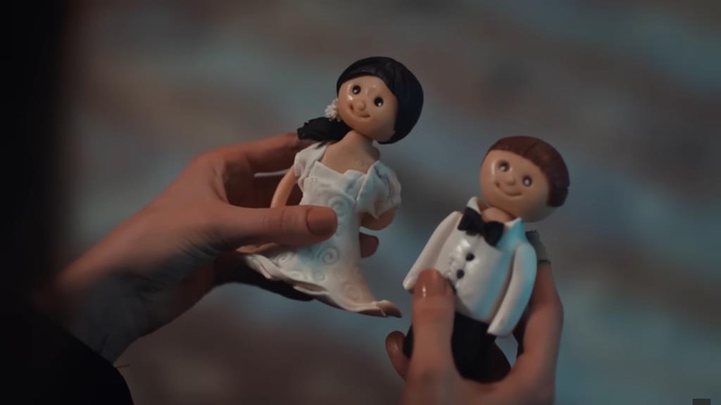 Zbliżenie na figurki z tortu, przedstawiające parę młodą.