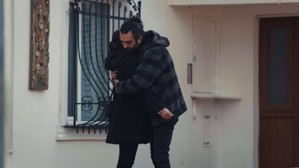 Ferit obejmuje Ayse na podwórku.