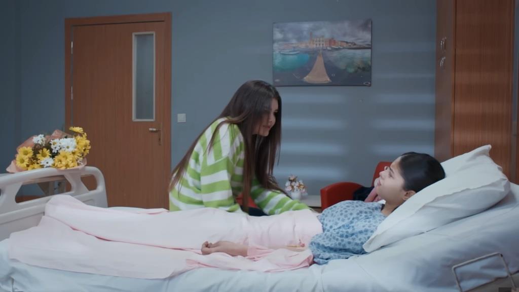 Nese rozmawia z siostrą w sali szpitalnej.