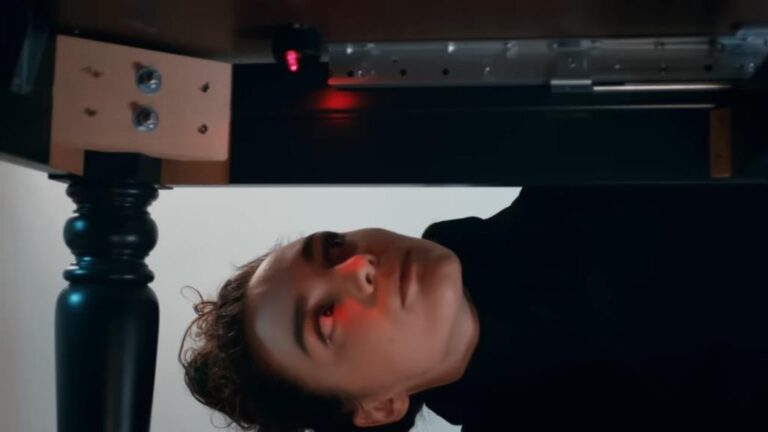 Nana znajduje urządzenie podsłuchowe pod biurkiem.