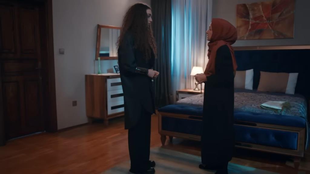 Nana i Akca rozmawiają wieczorową porą w pokoju, oświetlonym przez pojedynczą lampkę nocną.