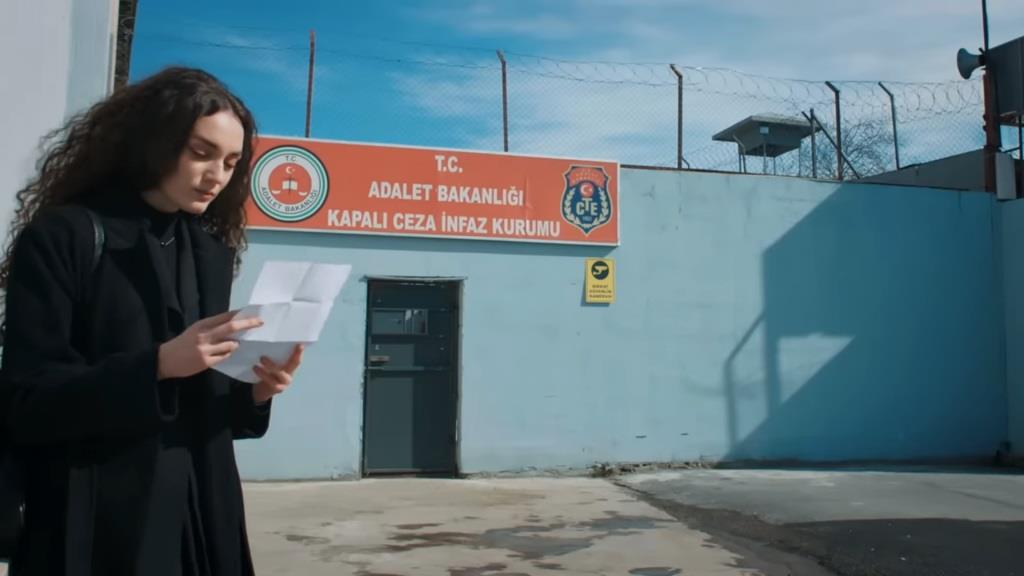 Scena na zewnątrz zakładu karnego. Nana czyta list od Yamana.