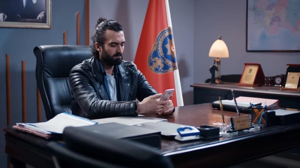 Ferit wpatruje się w ekran telefonu.